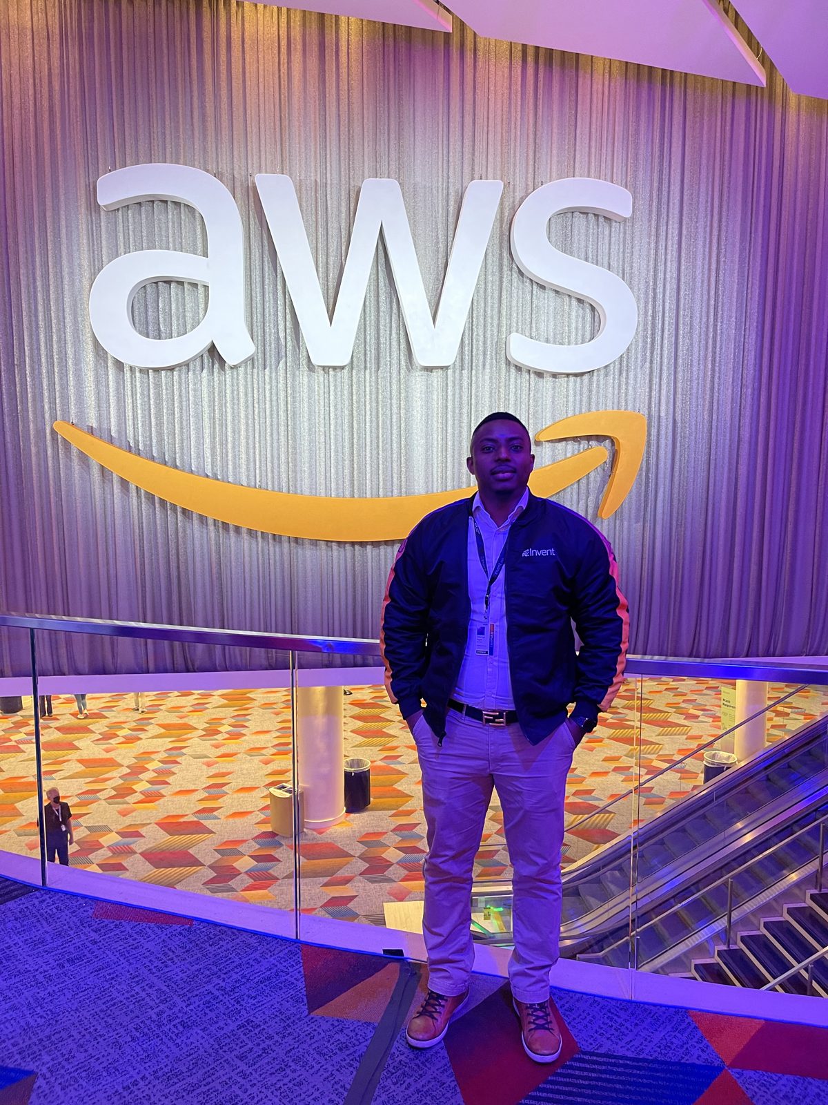 Dibongo Ngoh under the AWS logo at re:Invent